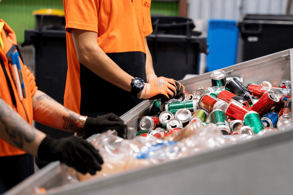 Workers at depot sorting plastics and aluminium cans