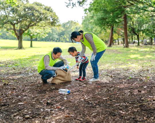 Family in park collecting containers in reusable bag